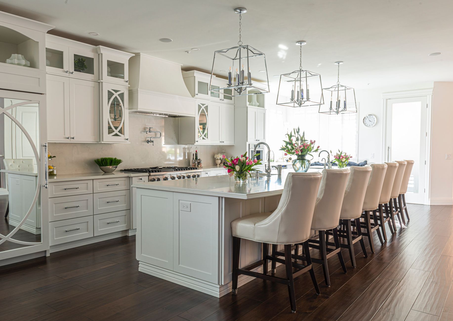 Beautiful modern kitchen interior featuring white cabinets, island, and elegant bar stools in Carlsbad, CA